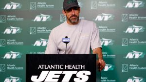 aaron rodgers speaking at a jets podium