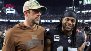 Aaron Rodgers of the New York Jets and Davante Adams visit on the field