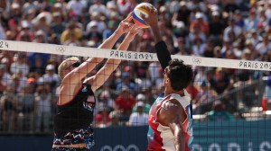 Team USA beach volleyball player Chase Budinger blocks a shot from Team France at the Olympics.