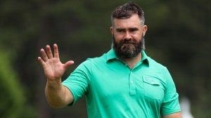 Jason Kelce waves to fans on the golf course.