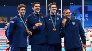 Team USA swim holds up gold medals.