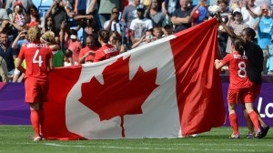 Members of Canada's women's soccer team holding flag