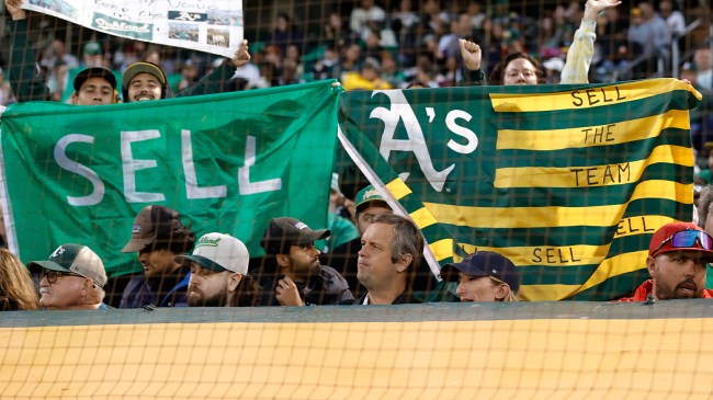 Oakland Athletics fans holding Sell the Team flags