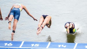 Women's competitors dive into the Seine River to start the triathlon.