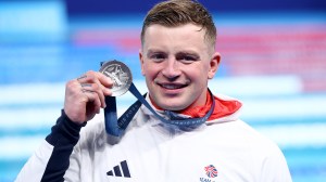 Swimmer Adam Peaty posing with silver medal at Olympics