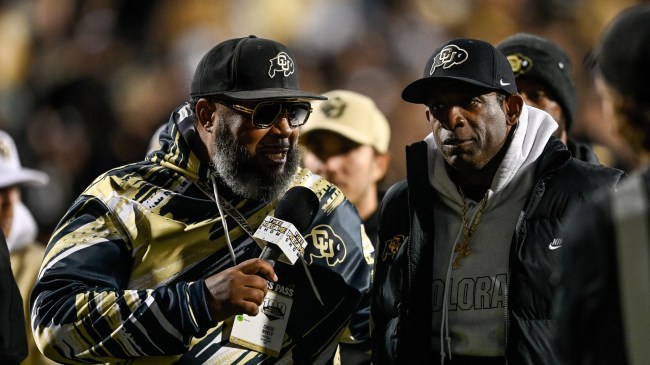 Deion Sanders talks to a sideline reporter during a Colorado football game.