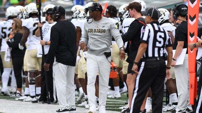 Deion Sanders walks the sidelines during a football game between Colorado and Oregon.