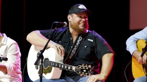 Luke Combs on stage with his guitar.