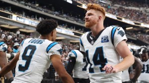 Andy Dalton high fives Bryce Young on the sidelines.