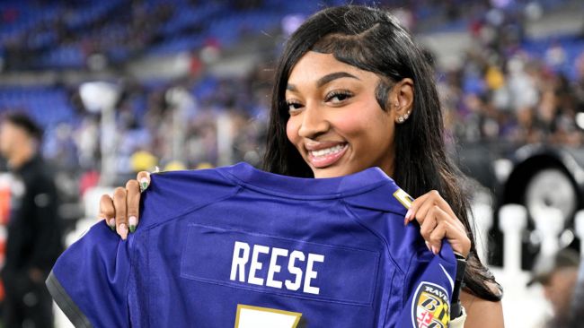 angel reese holding a custom baltimore ravens jersey