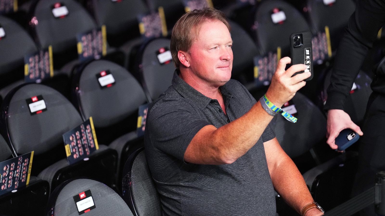 Jon Gruden holding his iPhone