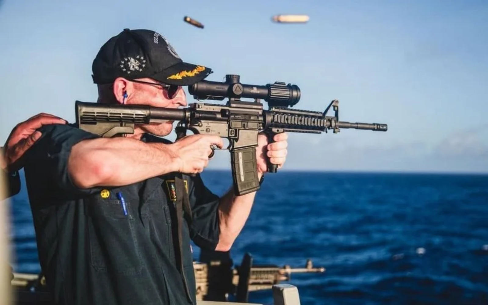 US Navy commander holding rifle with backward scope