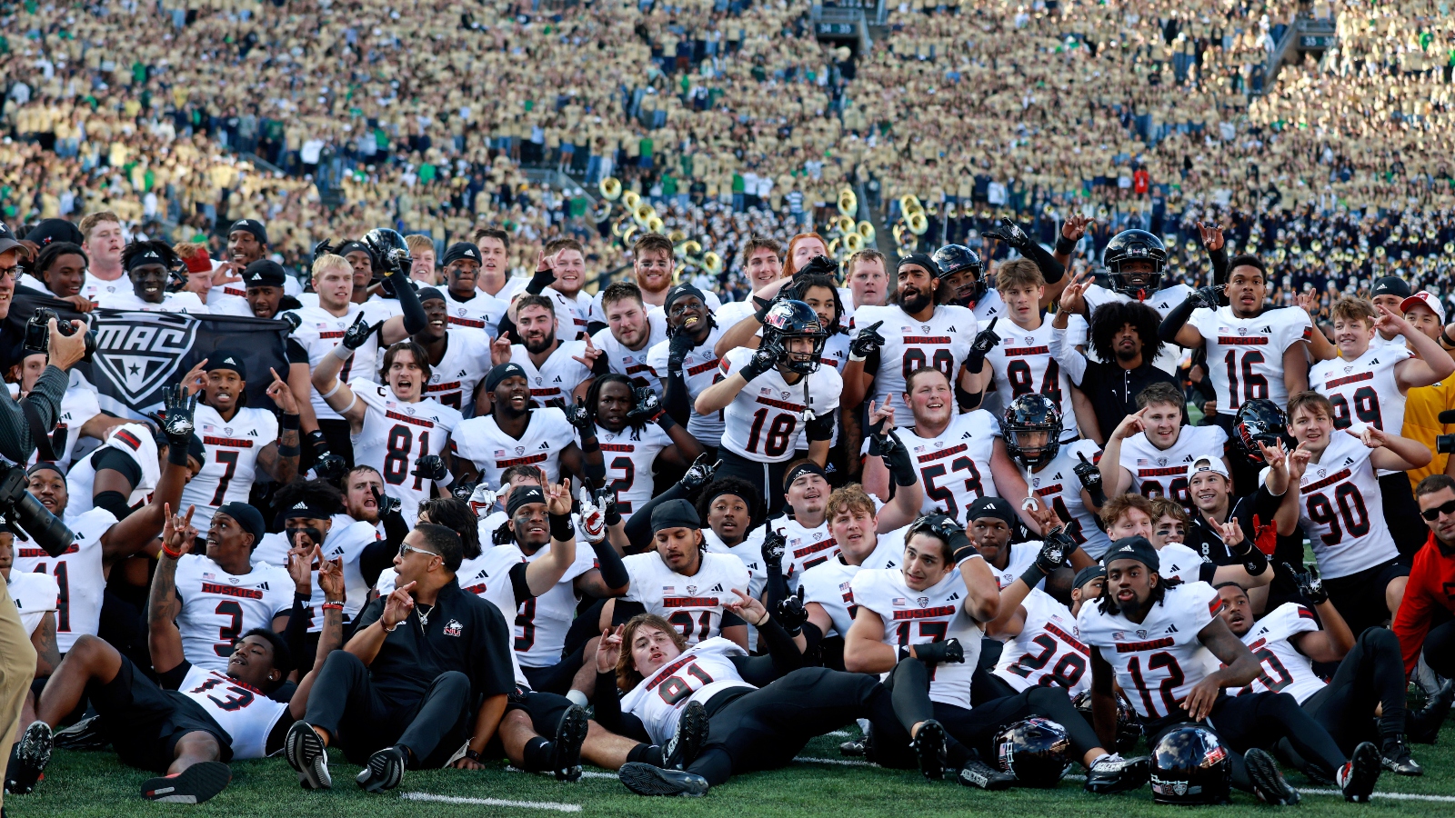 NIU Huskies Football program pose on the field after upsetting 5th ranked Notre Dame