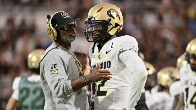 Colorado football coach Deion Sanders talks to son, Shedeur, on the sidelines.