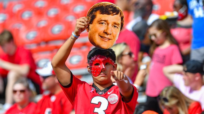 A Georgia football fan holds a cut out of Kirby Smart.