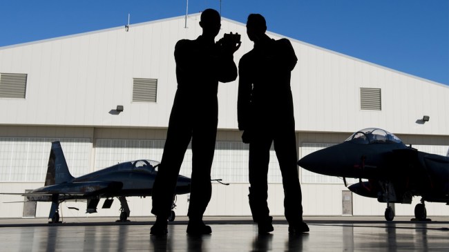 Pilots with the US Air Force stand inside a hangar