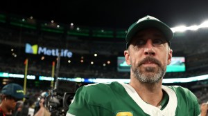 New York Jets QB Aaron Rodgers on the field after a game.