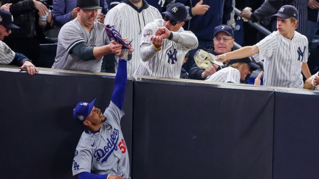 Yankees fans try to rip the ball away from Mookie Betts in Game 4 of the World Series.