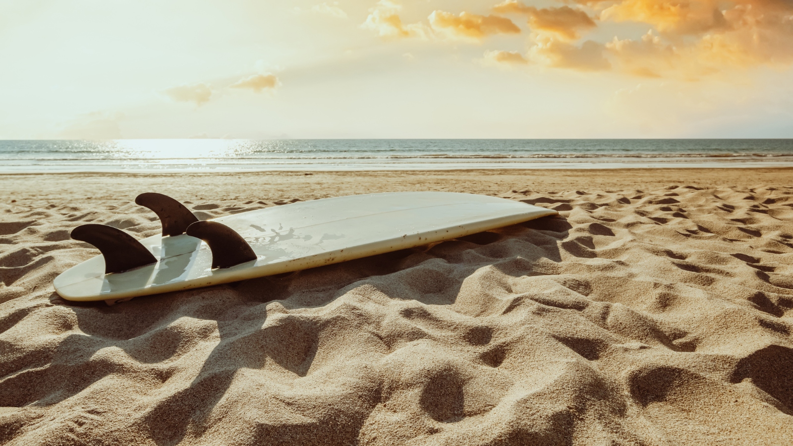 surfboard laying on the sand