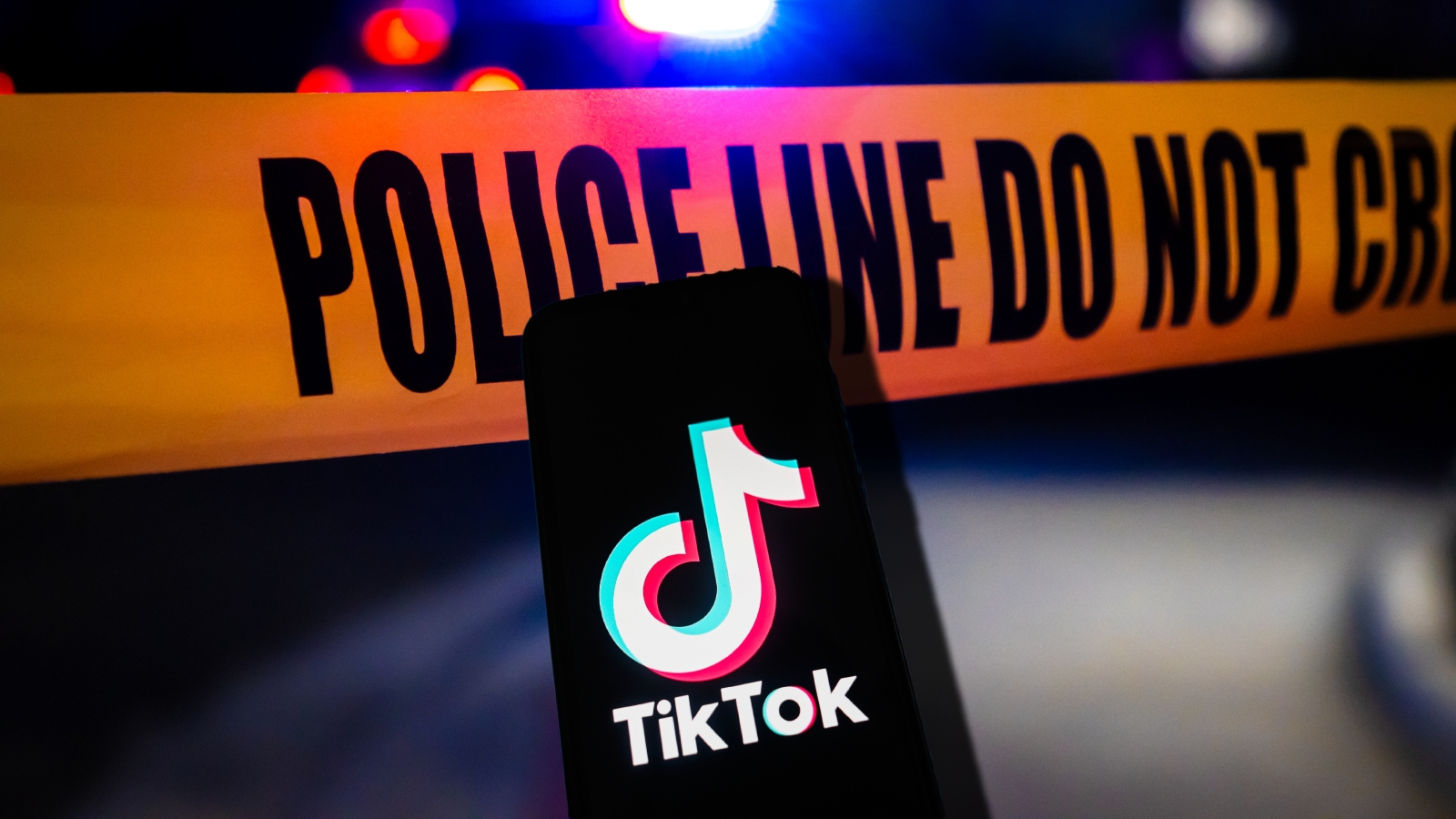 image of TikTok app on iPhone and Police yellow tape