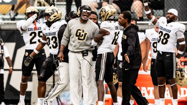 Colorado football coach Deion Sanders celebrates with his team on the sidelines.