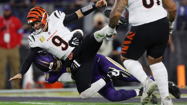 Bengals QB Joe Burrow gets hit by a Ravens defender after throwing a pass.