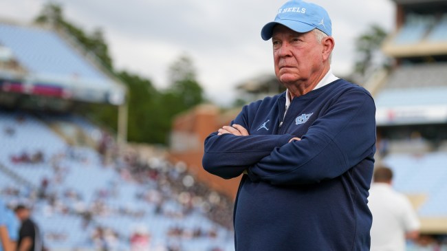 UNC football coach Mack Brown stands on the field before a game.