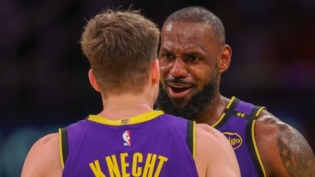 Los Angeles Lakers players LeBron James and Dalton Knecht on the floor.