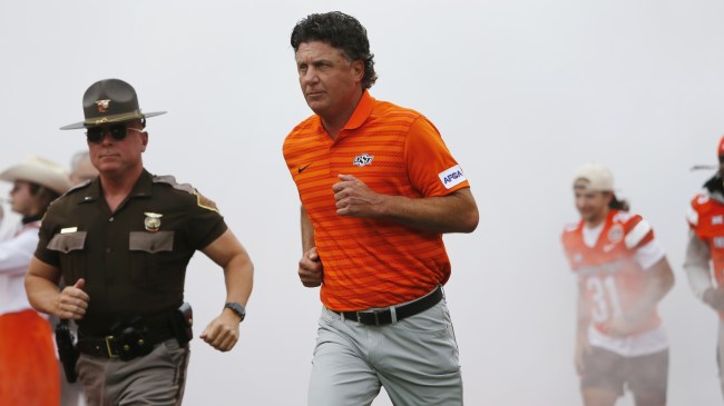 Mike Gundy leads the Oklahoma State football team onto the field.