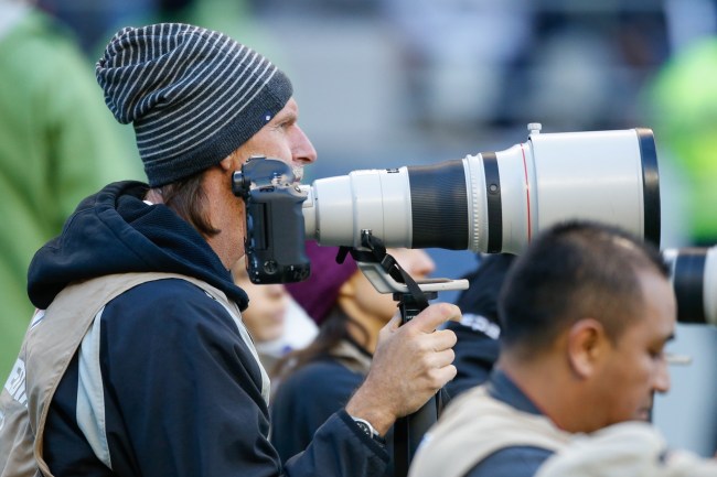  Former Major League baseball pitcher Randy Johnson photographs from the sidelines during the game between the San Francisco 49ers against the Seattle Seahawks at CenturyLink Field on November 22, 2015 in Seattle, Washington.
