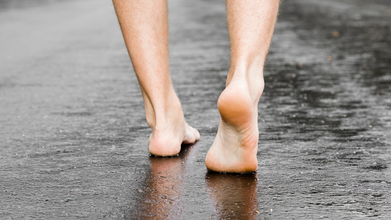 man walking barefoot on the road