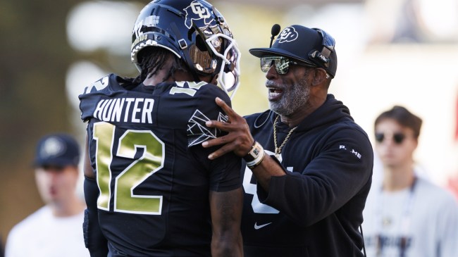 Colorado football coach Deion Sanders speaks to Travis Hunter.