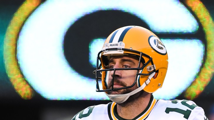 Aaron Rodgers in front of Packers logo