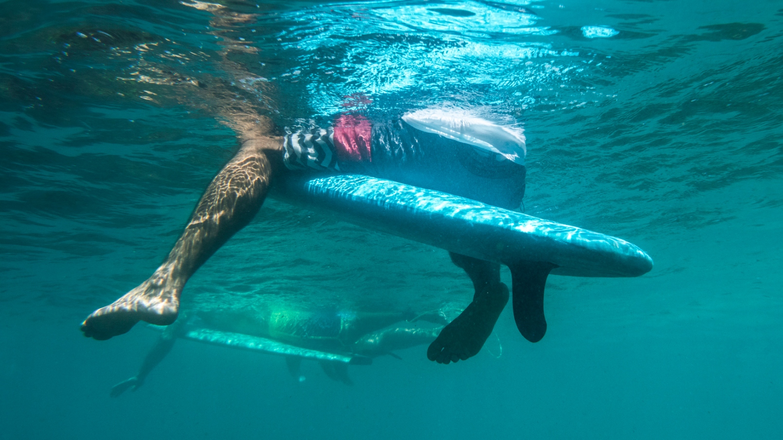 surfer dangling his legs in the water