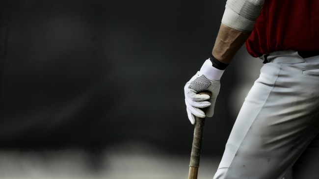 A baseball player waits in the on-deck circle.