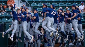 UTSA baseball players celebrate after scoring a run against Texas.