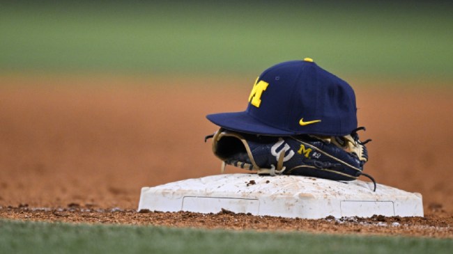 A Michigan baseball player's hat and glove on the infield.