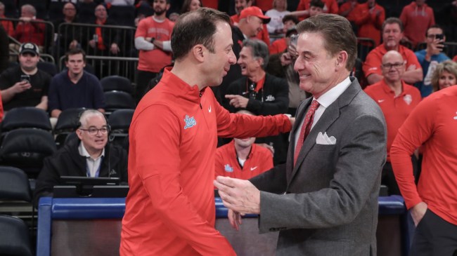 Rick Pitino and Richard Pitino shake hands before a basketball game.