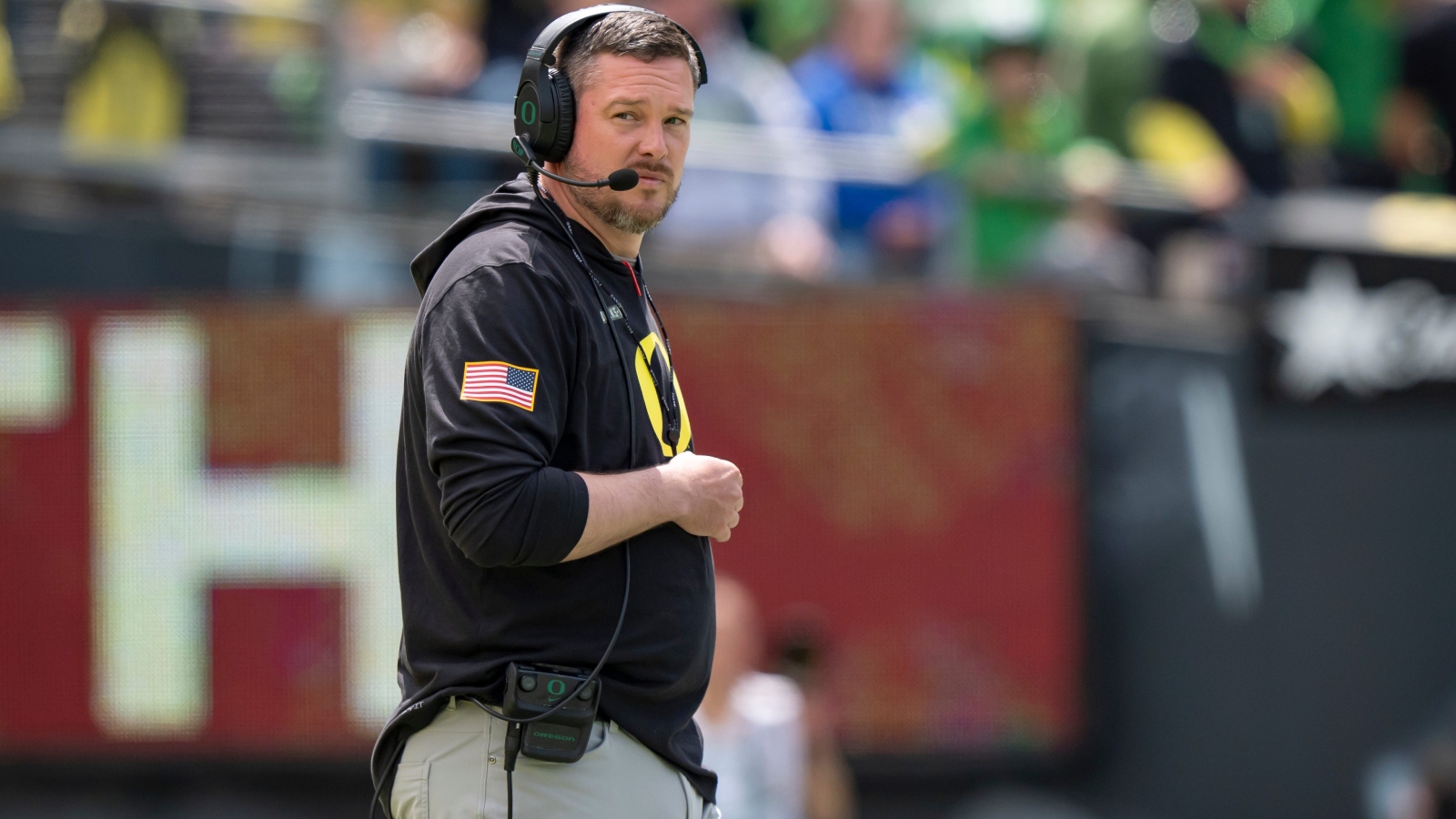 Oregon football coach Dan Lanning walks onto the field.