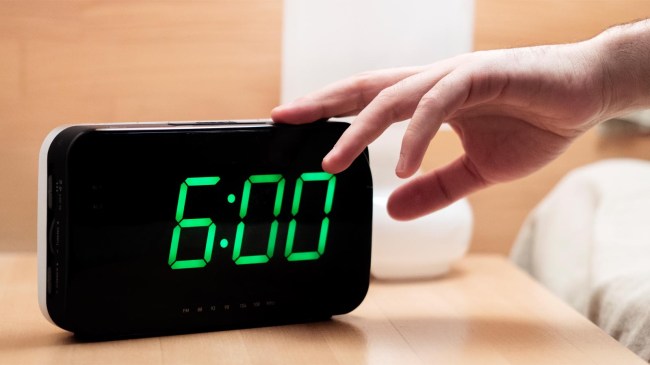 man-hitting-snooze-alarm-on-clock