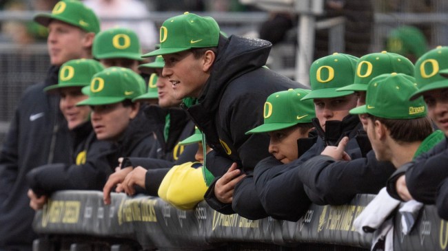 Oregon baseball players watch from the dugout
