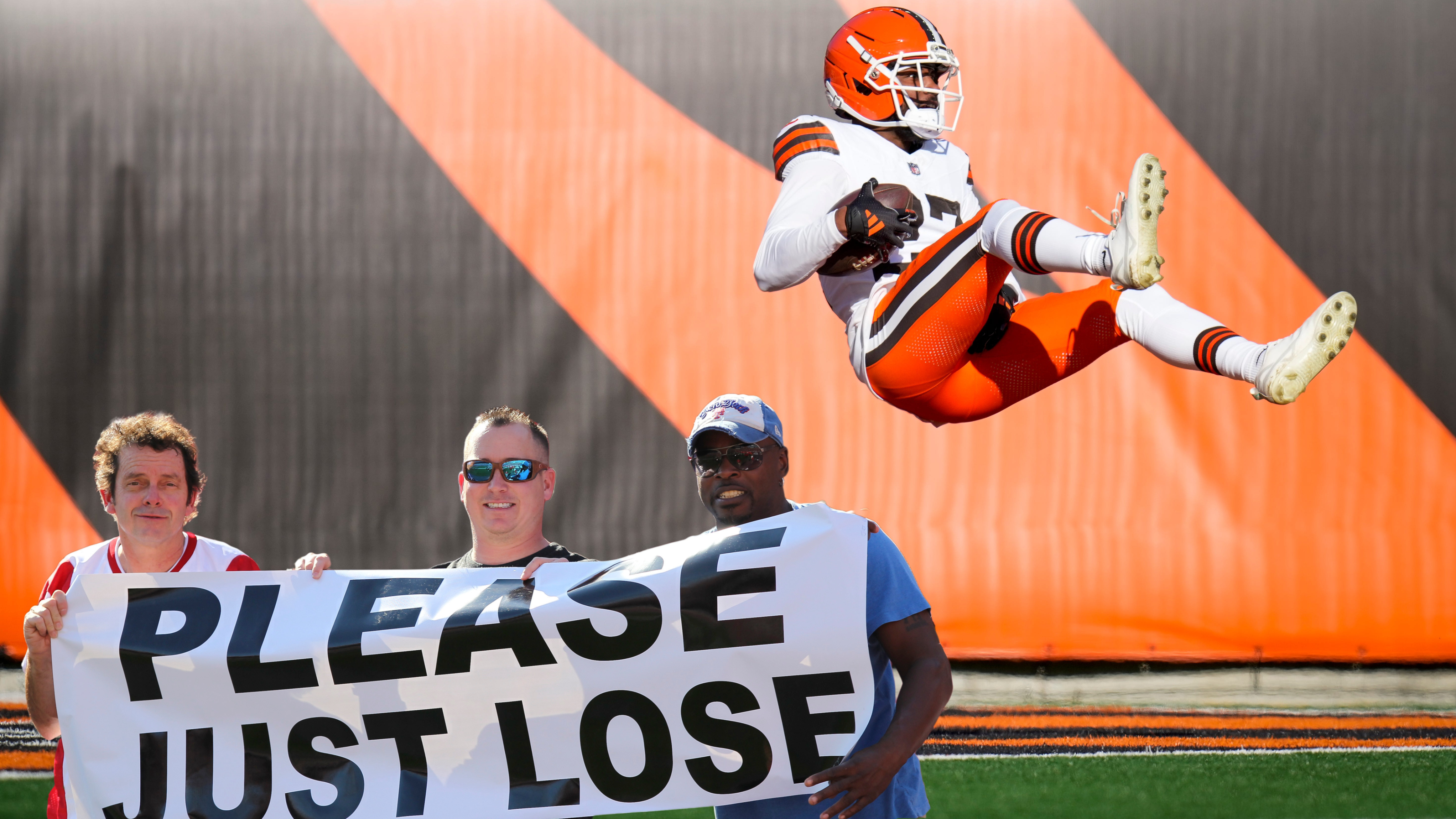 NFL fans holding up 'please just lose' sign in front of losing player