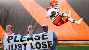 NFL fans holding up 'please just lose' sign in front of losing player