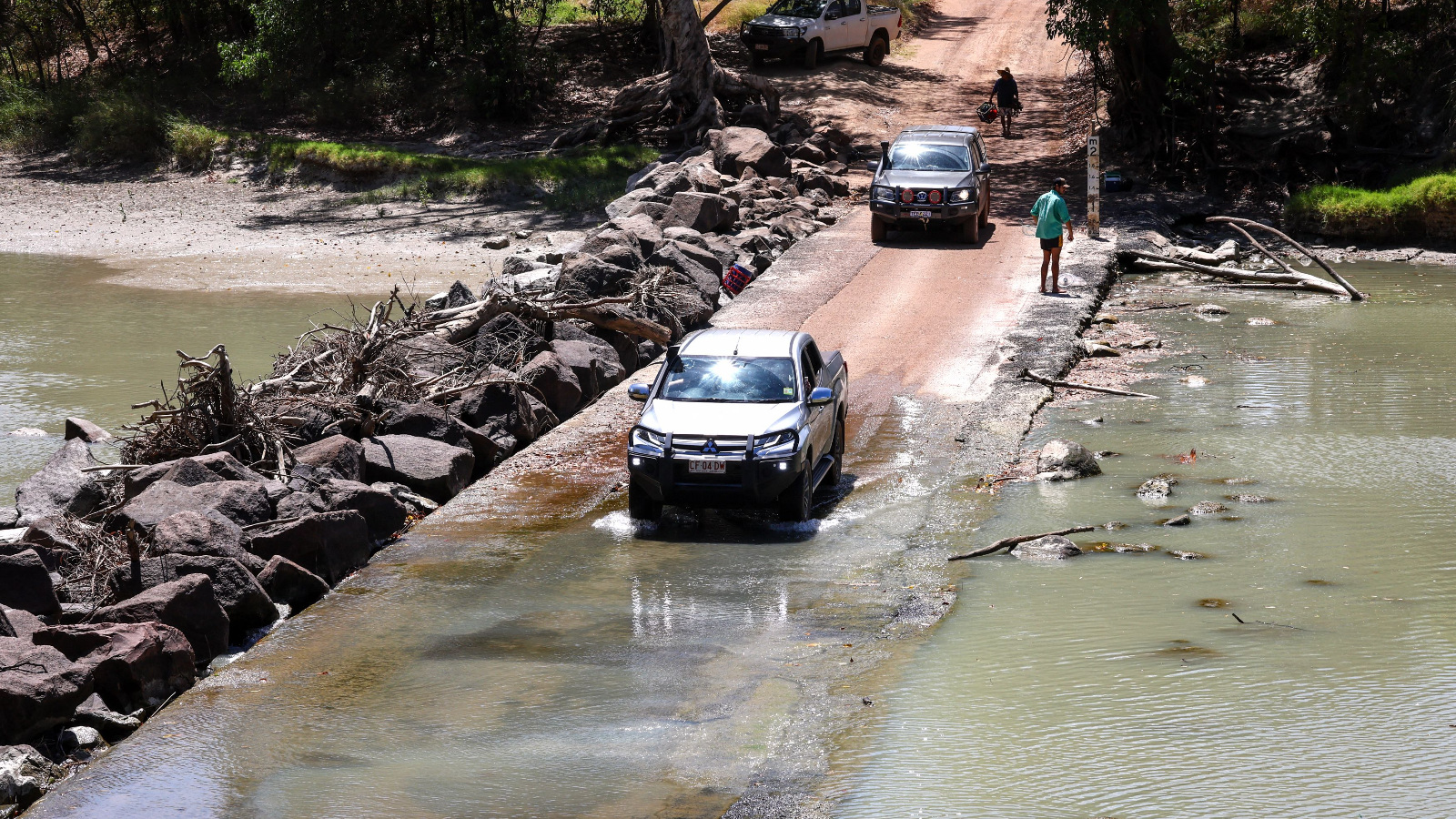 truck passes crocodiles at Australia's Cahills Crossing in the Northern Territory