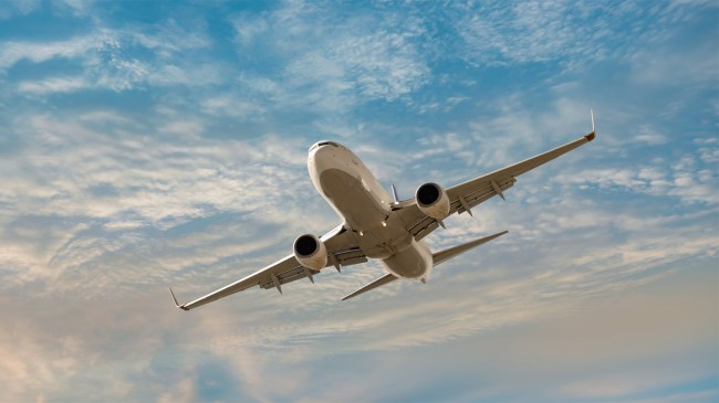 Airplane-flying-over-tropical-sea-at-sunset