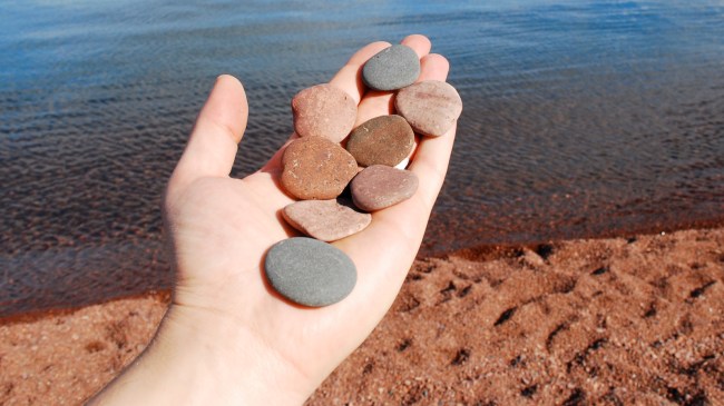 person holding skipping stones