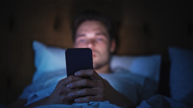 Man-Uses-Smartphone-in-Bed-at-Night