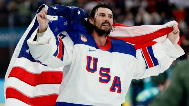 Team USA goaltender Connor Hellebuyck with American flag at Winter Olympics