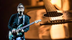Weezer's Rivers Cuomo on front of an acoustic guitar