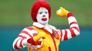 Ronald McDonald throwing pitch at baseball game